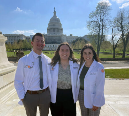 Student Doctors Jett Murray, Madison Summers and Makayla Bussman smile in front of the U.S. Capitol.